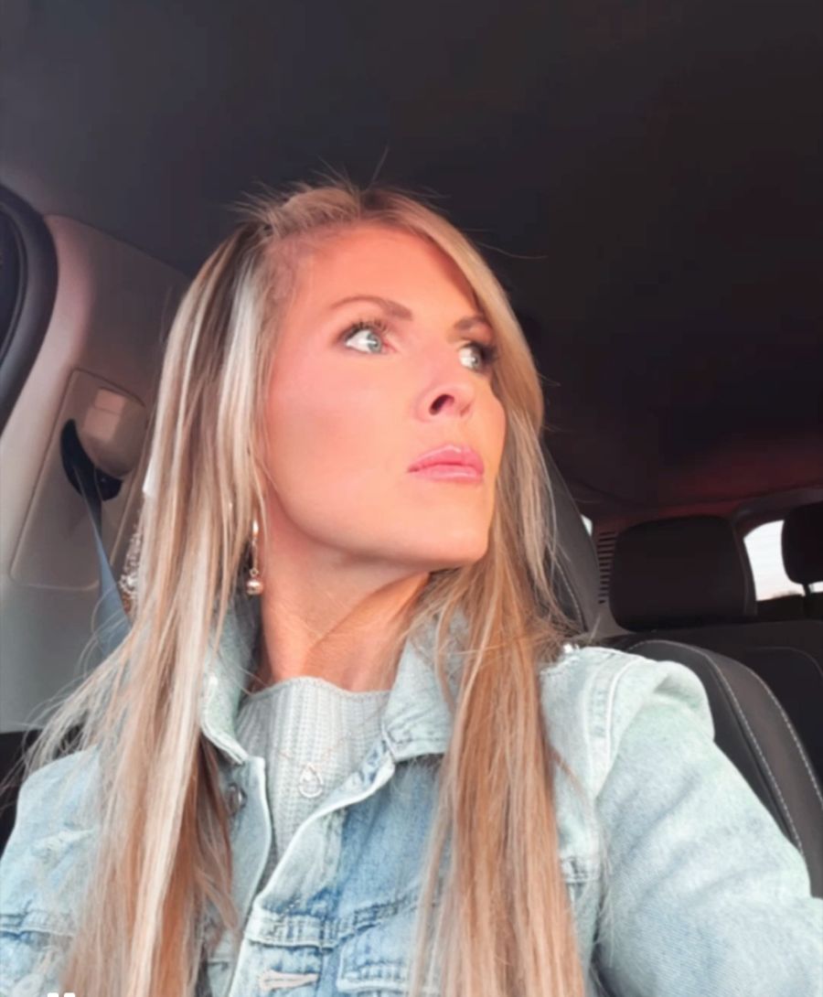 Natalie in her car, looking out the window, deep in thought